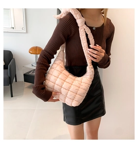 Primer plano del bolso acolchado rosa claro con un elegante nudo en la correa del hombro