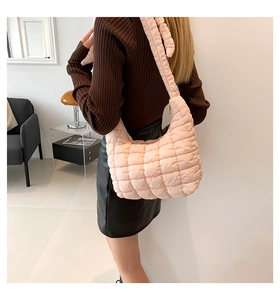 Vista trasera de un bolso acolchado rosa llevado por una modelo con ropa informal
