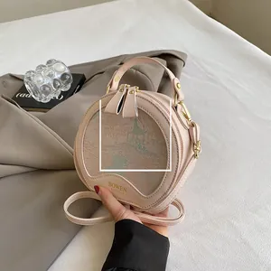 Detailed view of pale pink circular handbag with oriental garden embroidery and metal hardware