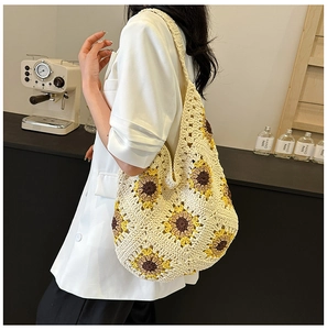 Détail d'un sac cabas au crochet avec tournesols porté par un mannequin en intérieur
