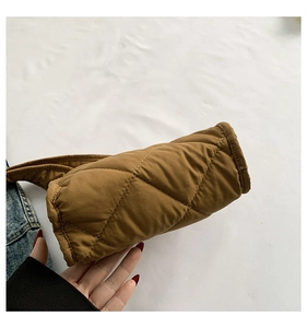 Detailopname van bruine gewatteerde schoudertas met ruitvormige stiksels