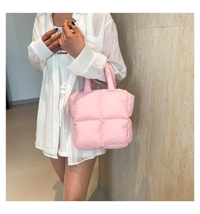 Detail of pink quilted down tote bag showing puffy texture and soft padding material