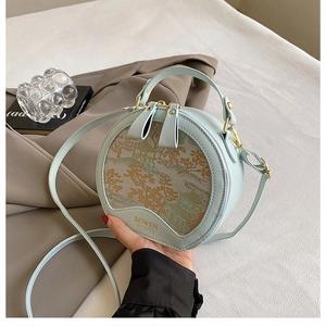 Detailed close-up of light blue round bag with traditional Chinese landscape embroidery