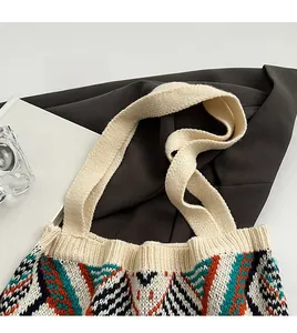Detail of wide knitted shoulder strap on bohemian tote bag with geometric patterns