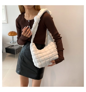 Detalle de un bolso de hombro acolchado blanco con un conjunto elegante y moderno