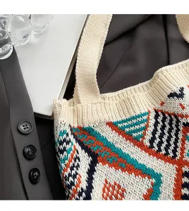 Close-up of bohemian knitted tote bag featuring geometric ethnic patterns and edge stitching