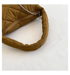 Gros plan sur le sac matelassé marron caramel avec détail de chaîne argentée chic