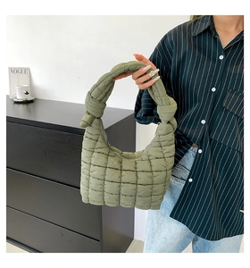 Vista detallada del bolso acolchado verde con un diseño único de asa con nudo suave