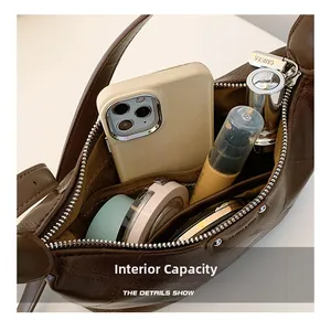 Internal capacity of the brown leather shoulder bag showing daily essentials inside