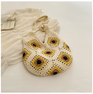 Détail d'un sac cabas en crochet tournesol avec large poignée sur fond esthétique