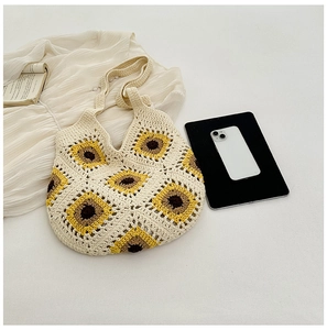 Détails des motifs de tournesol au crochet sur le sac tissé crème avec textures vives