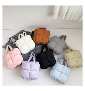 Flat lay of colorful puffer shoulder bags in eight shades with denim jacket detail