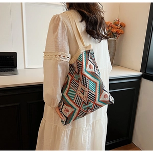 Detail of bohemian knit tote bag showing colorful geometric ethnic patterns and shoulder strap