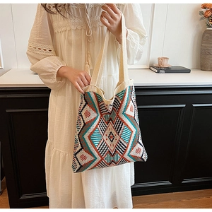 Close-up of bohemian knit tote bag showing colorful geometric patterns and fabric texture