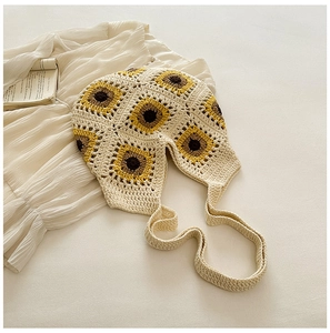 Gros plan détaillé du motif crochet tournesol sur un sac à bandoulière en maille crème