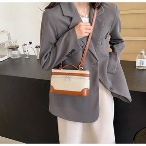 Détail du sac bandoulière en toile avec finitions cuir porté par un mannequin