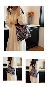 Macro view of bohemian knit tote bag with colorful geometric patterns and black shoulder strap