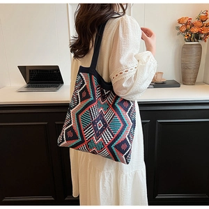 Detail of bohemian knit tote bag showing colorful geometric patterns and woven texture