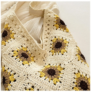 Vue détaillée du crochet fait main et des motifs de tournesol sur le sac en tricot
