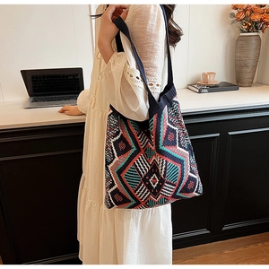 Detail of vintage knit tote bag with bohemian geometric pattern worn over the shoulder