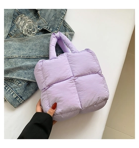 Detail of lavender quilted puffer bag with soft padded handle and matte textured fabric
