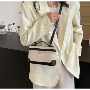 Détail d'un mini sac cabas rétro en toile avec garniture en cuir noir porté sur un costume