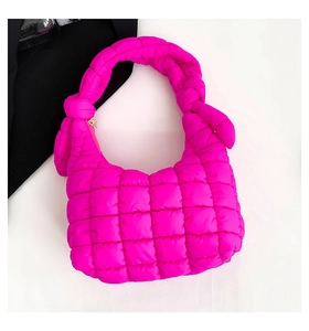 Detalle del bolso acolchado rosa fucsia con asa anudada y cremallera de metal dorada