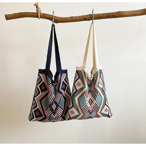 Close-up of geometric jacquard patterns on vintage bohemian knitted tote bag textures