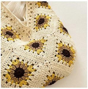 Vue rapprochée de la texture crochetée à la main et des motifs de tournesols sur le sac