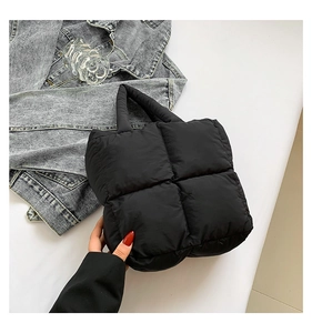 Detail view of large capacity black quilted puffer tote bag with soft padded handles