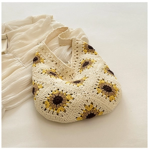 Gros plan détaillé du motif de tournesol au crochet sur le sac à bandoulière tissé crème