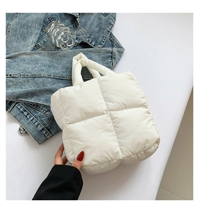 Detailed view of the white quilted puffer handbag with large grid stitching design