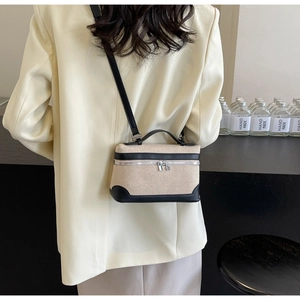 Détail d'un sac à main en toile contrastée avec bordure en cuir noir et double zip