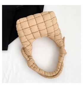Detalle del bolso tote beige acolchado de damero con elegante correa de nudo decorativa