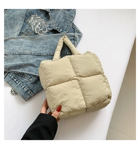 Detail of beige quilted puffer tote bag with soft padded handle for winter fashion