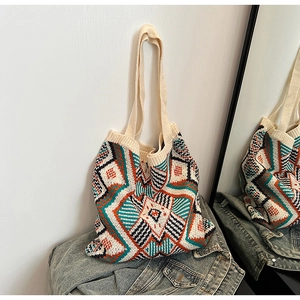 Macro shot of ethnic geometric knit tote bag fabric laid on a blue denim jacket