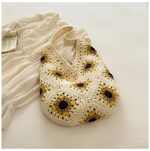 Détails des motifs de tournesol au crochet et texture tricotée sur ce sac cabas crème