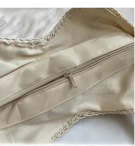 Detailed close-up of crochet tote bag featuring smooth metal zipper and beige fabric lining