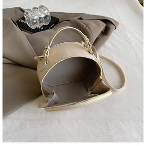 Detail view showing the spacious interior and textured herringbone lining of the round bag