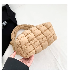 Primer plano del bolso acolchado caqui con textura suave y asa de hombro gruesa