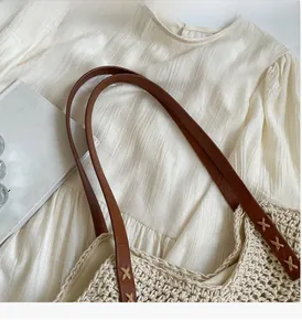 Detail of crochet cotton shoulder bag with leather handles and cross stitching