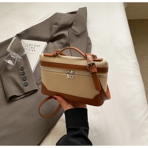 Détails du sac boîte vintage avec texture tissée, bordure en cuir et doubles zips argentés
