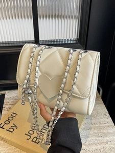 Quilted cream crossbody bag with large heart flap and elegant silver chain strap