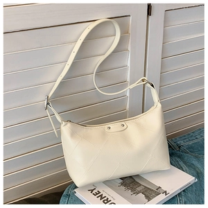 Detail of light beige hobo bag showing large diamond quilting and adjustable strap