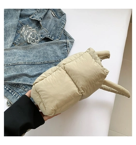 Detail of beige quilted puffer tote bag with soft padded handles and nylon diamond texture