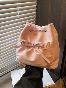 Bolso saco rosa con cordón ajustable, adorno de lazo y cadena plateada