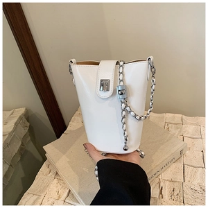 Détail du sac seau en cuir PU blanc avec fermoir argenté et bandoulière en chaîne