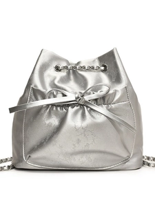Bolso tipo cubo plateado con relieve floral, acabado metálico y lazo decorativo
