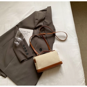 Détail de la toile vintage et des coutures en cuir marron sur le sac bandoulière
