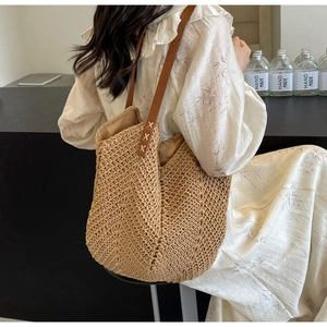 Detail of V-shaped woven straw pattern and leather shoulder strap with X-stitch